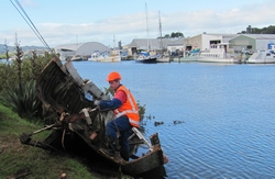 Maritime Officer Craig Gardner secures one of two abandoned boats prior to their removal from Whangarei's Waiarohia canal recently.